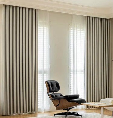 Beige curtains with sheer panels, lounge chair