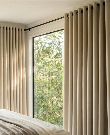 Cream eyelet curtains framing green garden view