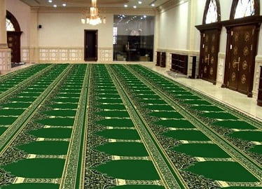 Green mosque carpet with mihrab arch row pattern