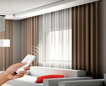 Hand using remote to operate brown and sheer curtains