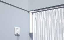 Motorized curtain track plugged into wall socket, white curtains