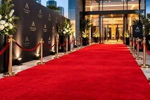 Red carpet corporate event entrance with gold stanchions