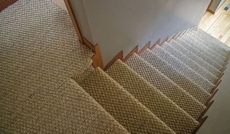 Sisal basketweave carpet installed on wooden staircase