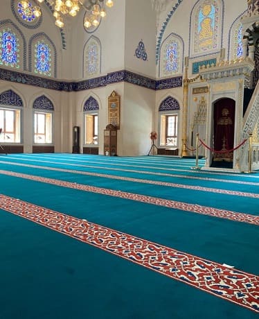 Teal mosque carpet with red patterned saff lines