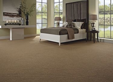 Textured tan sisal-style carpet in elegant bedroom