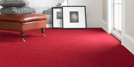 Vivid Scarlet Plush red carpet in a cozy living room with leather ottoman