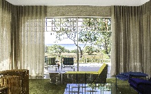 linen Sheer olive curtains framing a retro living room with garden view